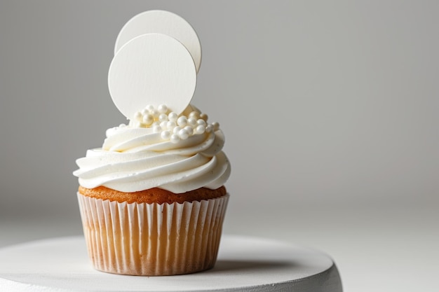 Un cupcake avec de la crème blanche et une plaque d'inscription sur un fond blanc