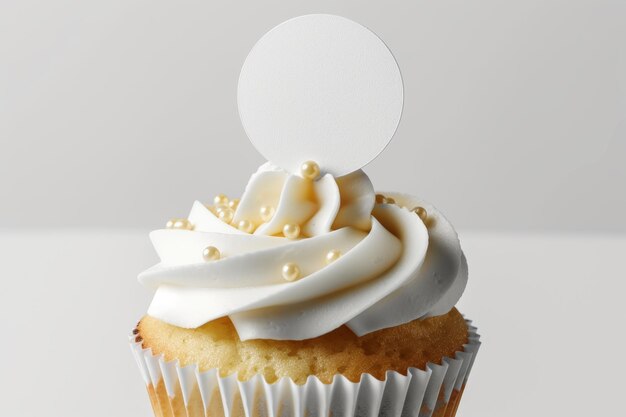 Un cupcake avec de la crème blanche et une plaque d'inscription sur un fond blanc