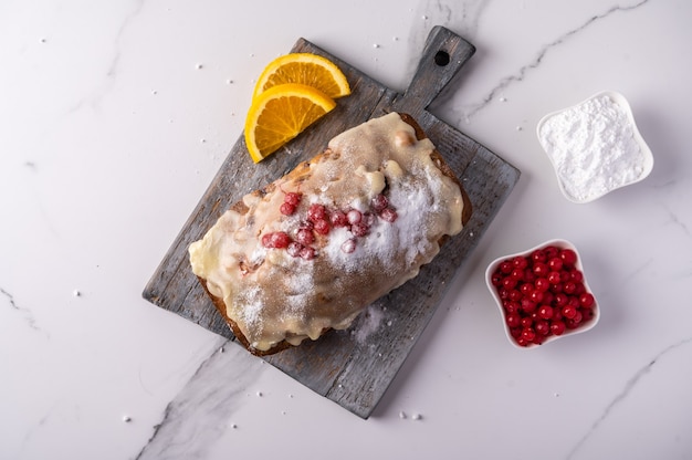 Cupcake fait maison avec des canneberges et du sucre glace et les ingrédients sur une planche à découper en bois