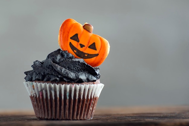 Cupcake d'Halloween avec des décorations de citrouilles en pain d'épice sur fond gris Muffins faits maison