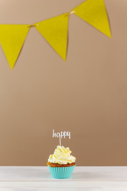 Cupcake avec Happy topper sur fond marron