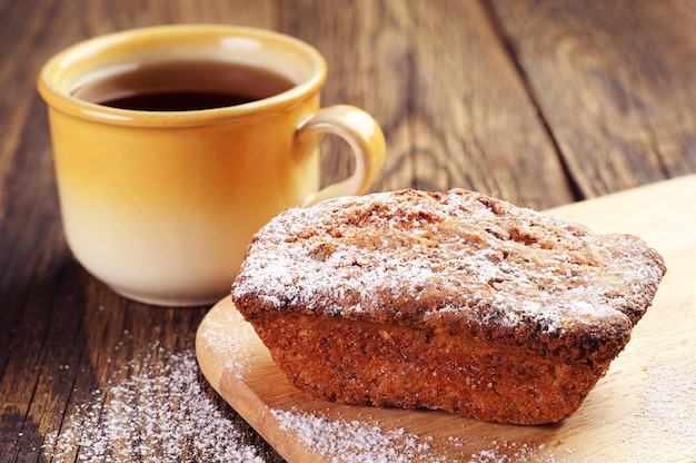 Cupcake sur une planche à découper et tasse de thé