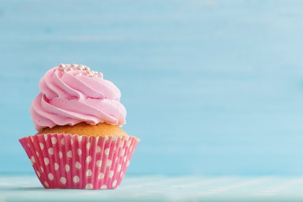 Cupcake rose sur un mur en bois bleu