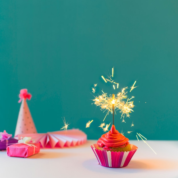 Photo cupcake avec sparkler brûlant sur fond vert