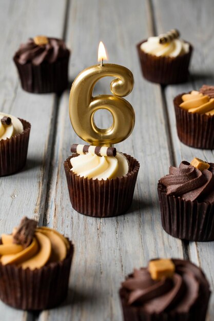 Cupcakes d'anniversaire de célébration du numéro 6 sur un fond en bois