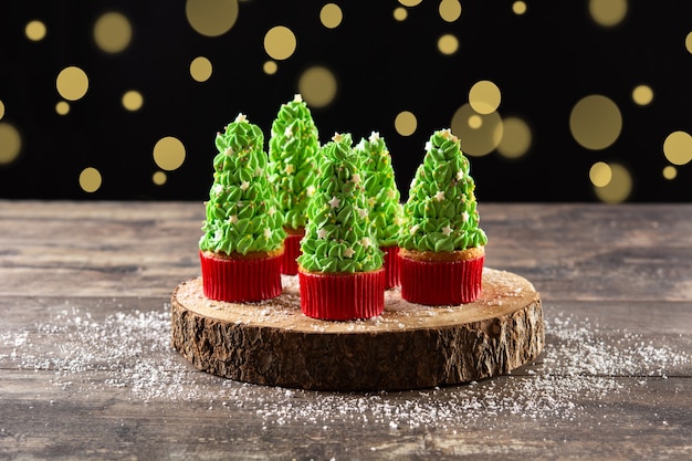 Cupcakes d'arbre de Noël sur la table en bois et l'arrière-plan flou