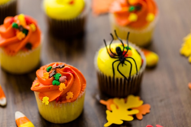 Cupcakes assortis avec glaçage jaune et orange décorés pour l'automne.