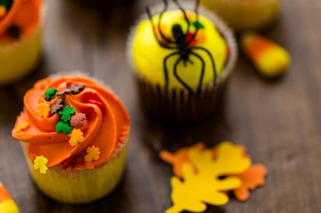 Cupcakes assortis avec glaçage jaune et orange décorés pour l'automne.