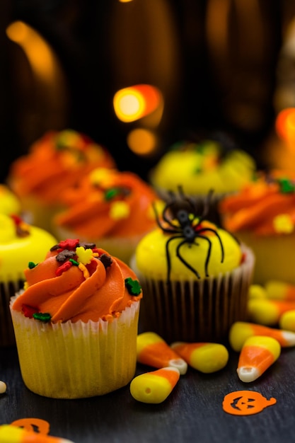 Cupcakes assortis avec glaçage jaune et orange décorés pour l'automne.