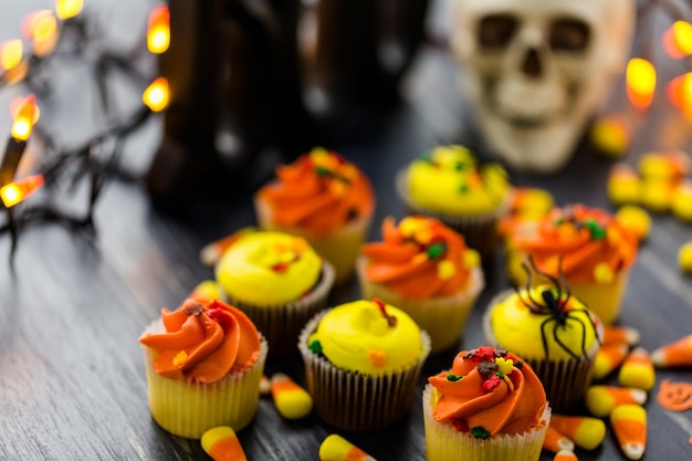 Cupcakes assortis avec glaçage jaune et orange décorés pour l'automne.