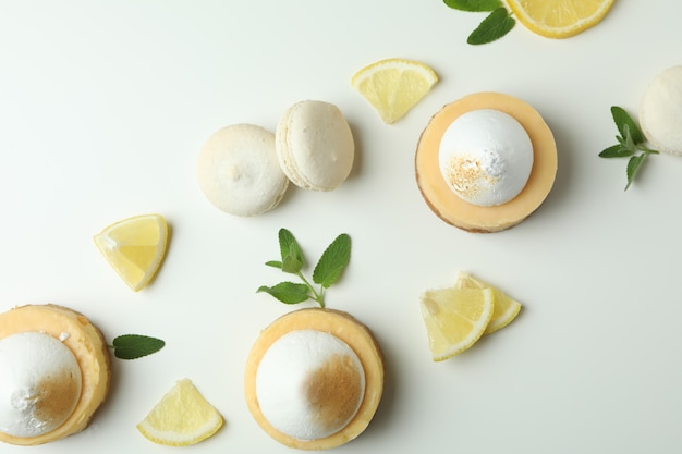 Cupcakes au citron, macarons et ingrédients sur fond blanc