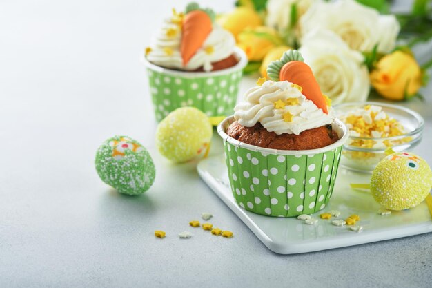 Cupcakes au gâteau aux carottes pour Pâques Cupcakes aux carottes avec glaçage au fromage à la crème décoré de minuscules carottes de pâte d'amande sur fond blanc Joyeuses Pâques et concept de vacances de printemps dessert maison de vacances