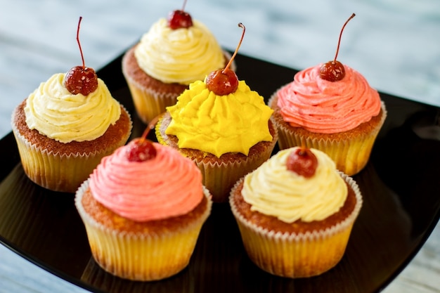 Cupcakes aux cerises sur le dessus de la pâtisserie sur plaque noire gâteries sucrées avec différentes saveurs comment surpr...