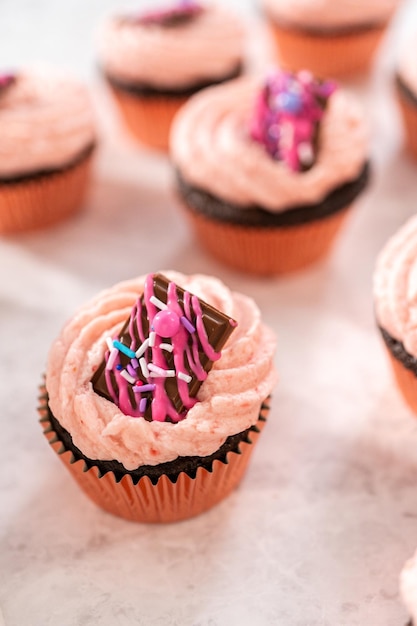 Cupcakes aux fraises au chocolat fraîchement cuits garnis de mini chocolats roses gastronomiques