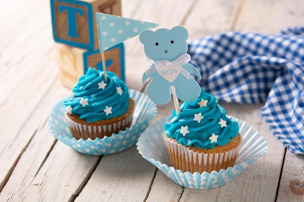 Cupcakes bleus pour baby shower sur table en bois