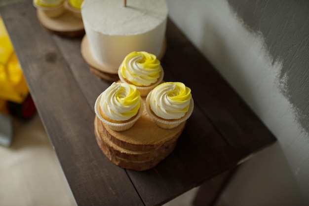 Cupcakes à la crème blanche et jaune sur un support en bois