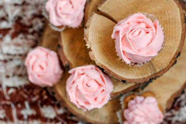 Cupcakes à la crème rose sur fond en bois.