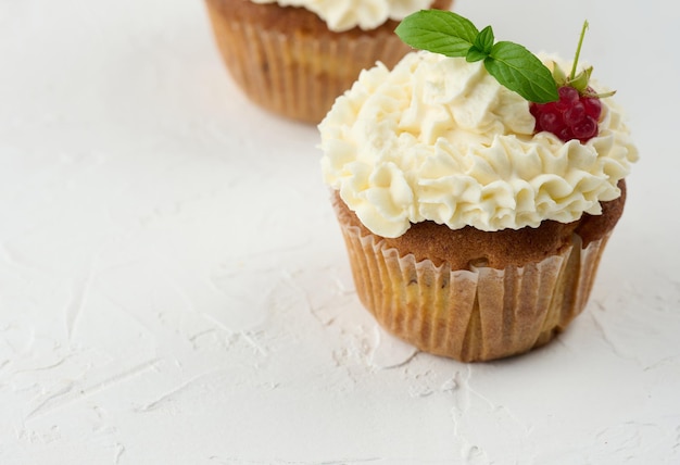 Cupcakes cuits au four avec crème au beurre blanc sur la table délicieux dessert