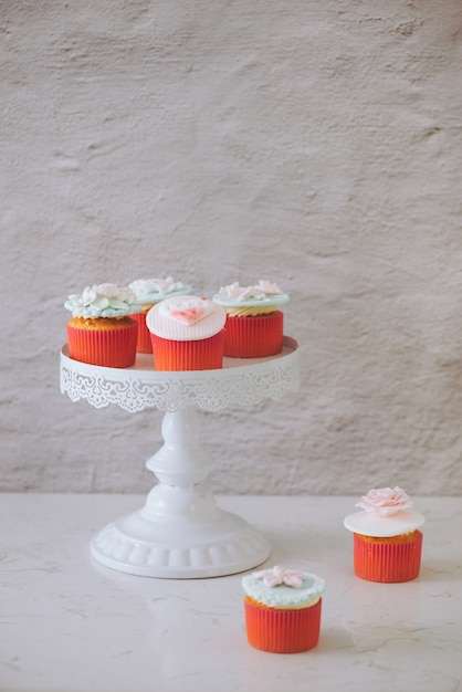 Cupcakes décorés de fondant. Cupcake d'amour doux de Valentine sur la table sur le fond clair