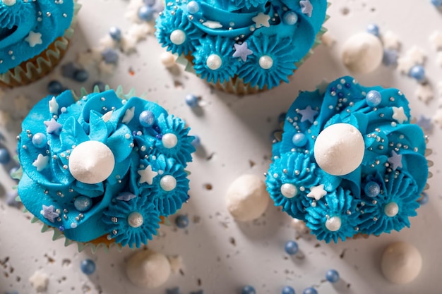 Photo des cupcakes faits maison et délicieux avec des éclaboussures et de la crème bleue