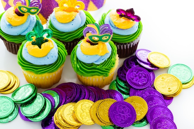 Cupcakes fantaisie décorés de feuilles et de masques pour la fête du Mardi Gras.