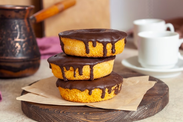 Photo cupcakes avec glaçage au chocolat sur le fond d'une cafetière et de tasses