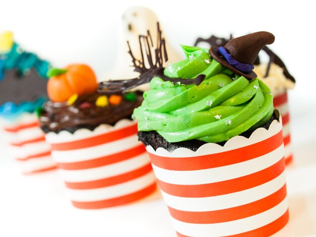 Cupcakes gourmands Halloween avec décor de vacances sur fond blanc.