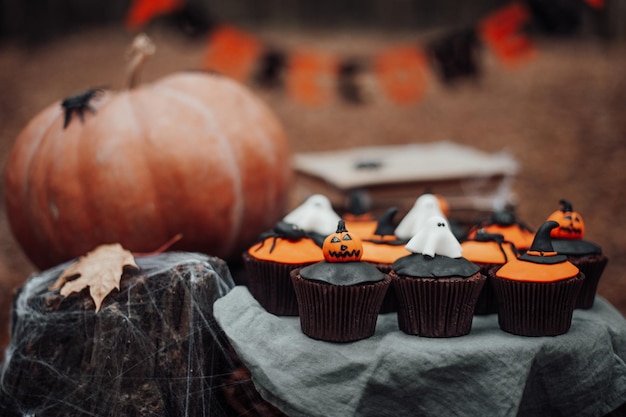 Cupcakes d'Halloween et décor de vacances à feuilles d'érable parmi les arbres en automne en plein air