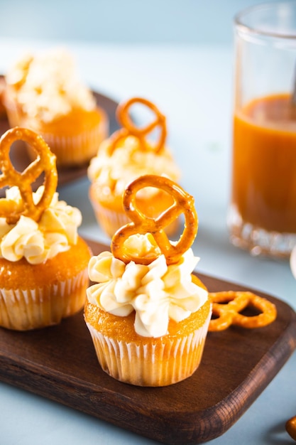 Cupcakes maison au sirop de caramel avec décoration de fromage à la crème fouettée et de gaufres de brezel