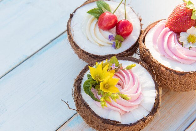 Cupcakes à la noix de coco avec fleurs, fraises et crème au fromage. Vue de dessus