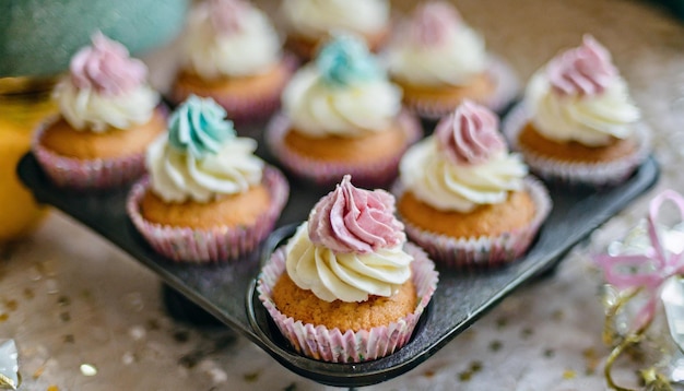 Des cupcakes ornés de glaçage coloré et de saupoudres arrangés pour une célébration festive.