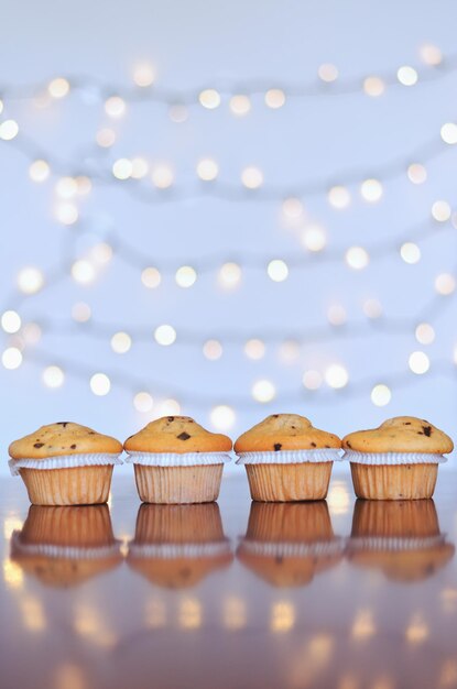 Cupcakes sucrés de Noël et bougies sous forme de nombres 2023. Fond blanc avec bokeh. Nouvel An