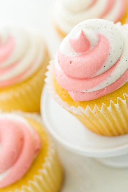 Cupcakes à la vanille garnis de crème à la fraise.