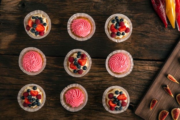 Cupcakes à la vanille avec des sacs de cuisson à la crème de figues fraîches avec de la confiture de fruits Vue de dessus