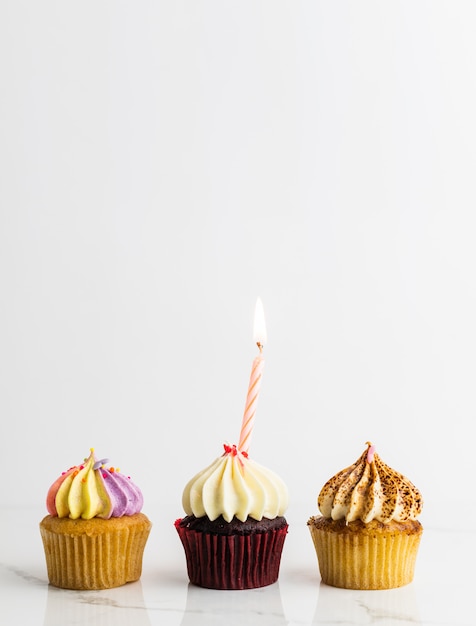 Cupcakes variété avec bougie fête d'anniversaire sur fond blanc, concept d'anniversaire