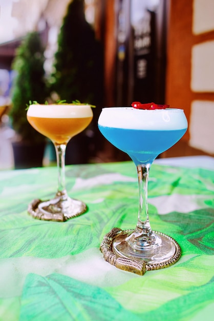 Curaçao bleu et cocktails beiges debout sur la table en plein air