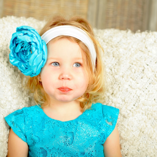 Curieux enfant fille souriante avec fleur bleue