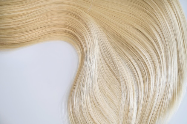 Curl femme cheveux sains Concept coiffeur salon spa mèche de cheveux soyeux blonds sur fond blanc