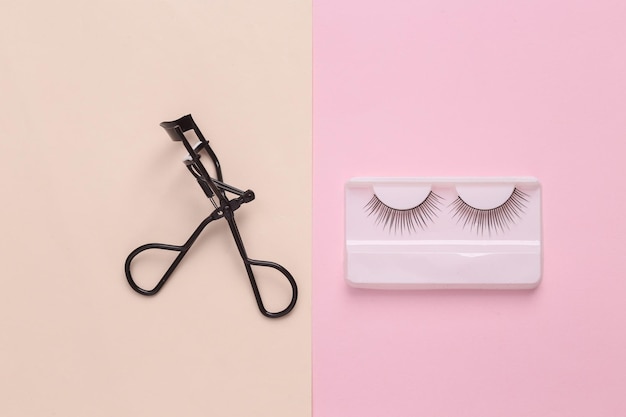 Curleur de cils professionnel avec de faux cils sur fond de couleur pastel Vue supérieure