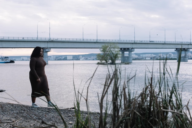 Curly blackhaired grave afro-américain dodue femme multiraciale se promener sur le lac de la rivière Mixed Race female at beach