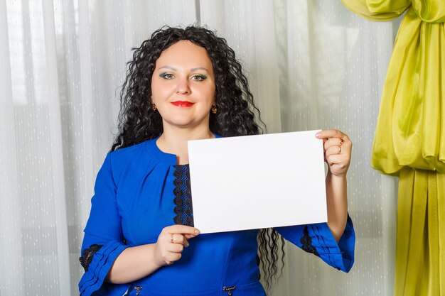 Curly Femme Brune Joyeuse Tenant Une Plaque D'espace Copie Dans Ses Mains. Photo Horizontale