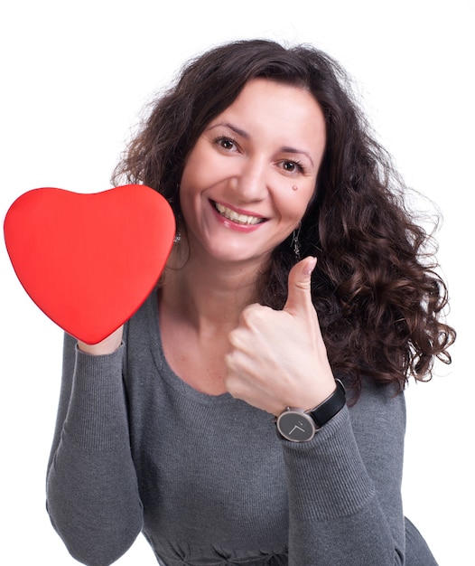 Photo curly woman holding heart et montrant oui signe sur fond blanc