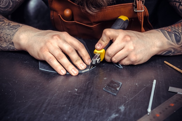 Currier en cuir travaillant avec du cuir sur le lieu de travail.