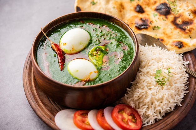 Le curry aux œufs d'épinards est un plat indien non végétarien à base de sauce palak avec des œufs