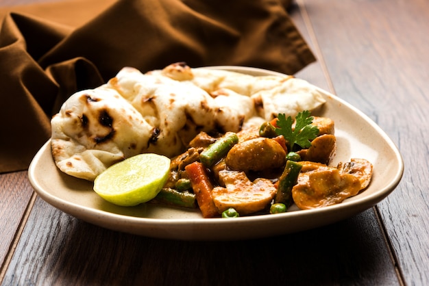 Curry de champignons indiens ou masala de champignons secs semi-secs avec roti ou naan ou pain plat, mise au point sélective