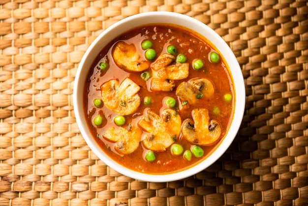 Curry de champignons et de pois avec de la nourriture indienne à l'ail rôti servi dans un bol