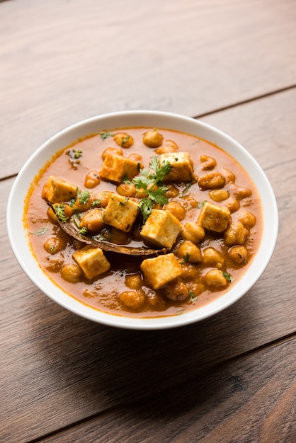 Curry Chole Paneer à base de pois chiches bouillis avec du fromage cottage aux épices. Recette populaire de l'Inde du Nord. servi dans un bol ou un plat de service. Mise au point sélective