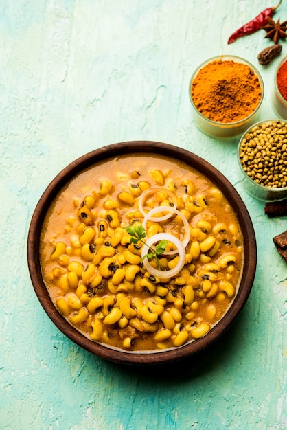 Curry de haricots noirs aux yeux noirs servi dans un bol avec naan et riz