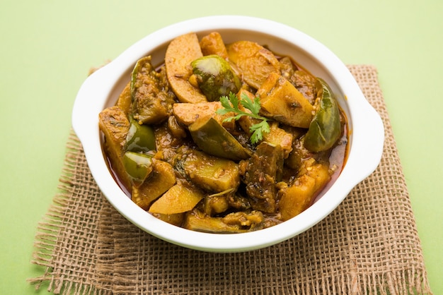 Curry indien épicé d'aubergines et de pommes de terre fait maison également connu sous le nom d'aloo Baigan ki sabzi en hindi, servi dans un bol kadhai ou blanc, mise au point sélective