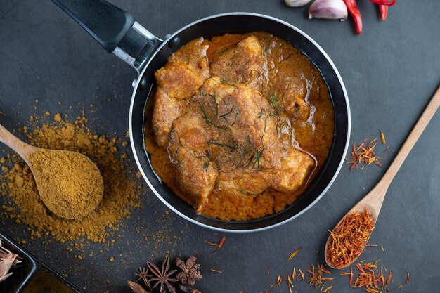 Photo curry massaman dans une poêle à frire avec des épices sur le sol en ciment